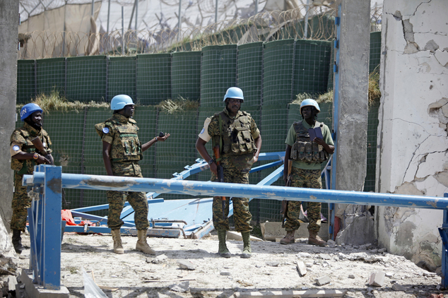 United Nations soldiers stand in front of the destroyed gate outside the UN's office in Mogadishu, Somalia, Tuesday, July, 26, 2016. A suicide bomber detonated an explosives-laden car outside the United Nations Mine Action Service offices in Mogadishu, killing 13 people, including seven U.N. guards, a Somali police official said. (AP Photo/Farah Abdi Warsameh)